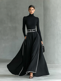 Gina – Vestido Largo Negro con Costuras Blancas y Cuello Alto, Manga Larga, Cintura Ceñida